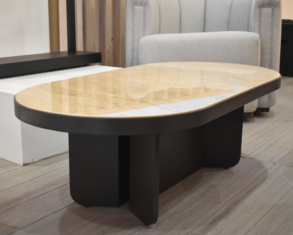 A sophisticated Caleb Coffee Table featuring a marble top and a dark wooden base, displayed in an elegant interior setting.