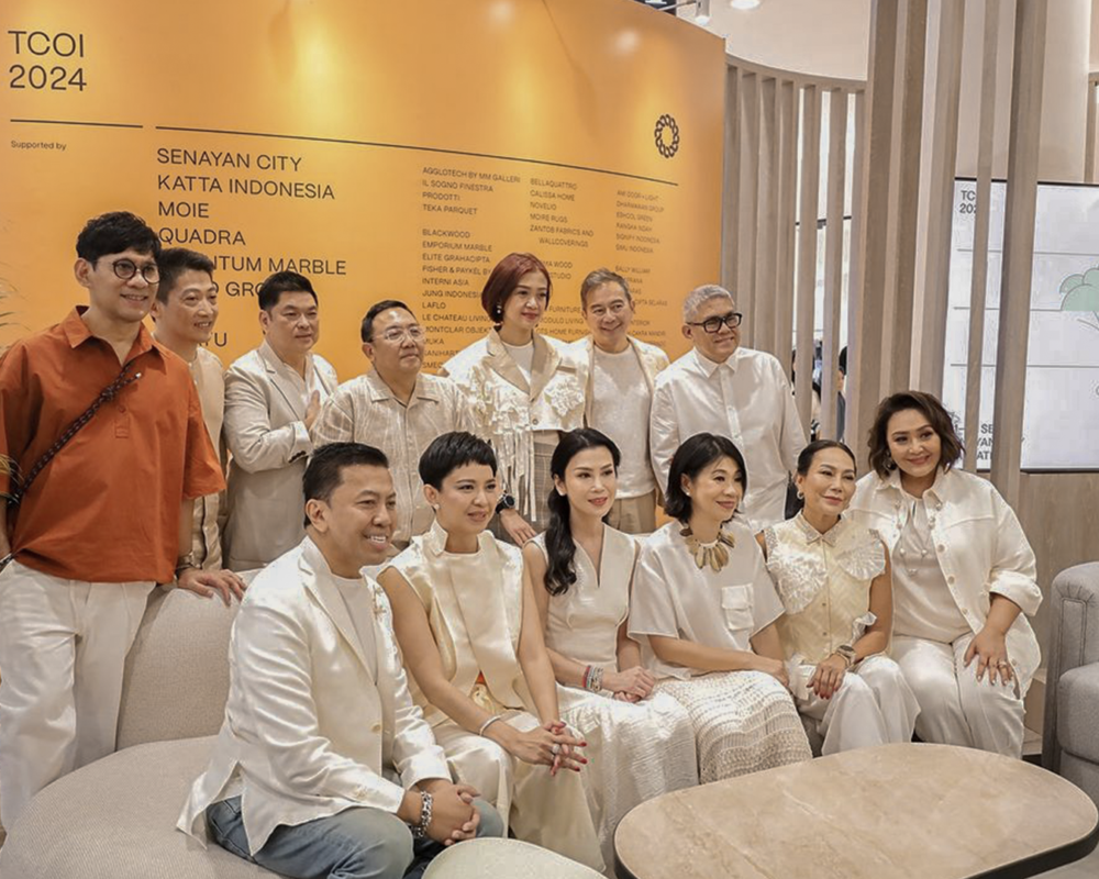 A group photo of Modulo Living team members at The Colours of Indonesia 2024, standing in front of their booth with stylish furniture pieces.