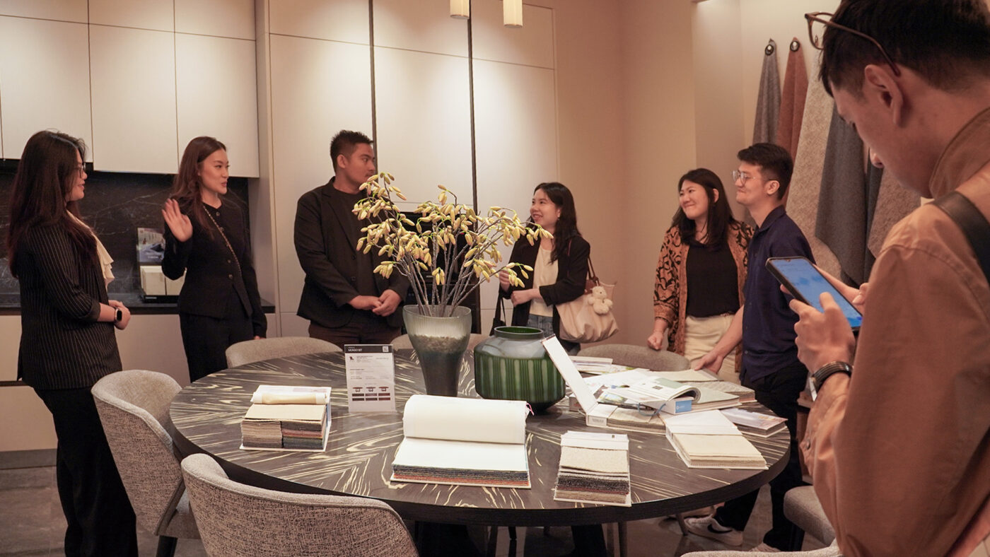 A group of designers gathered around a round table with books and décor pieces in the showroom.