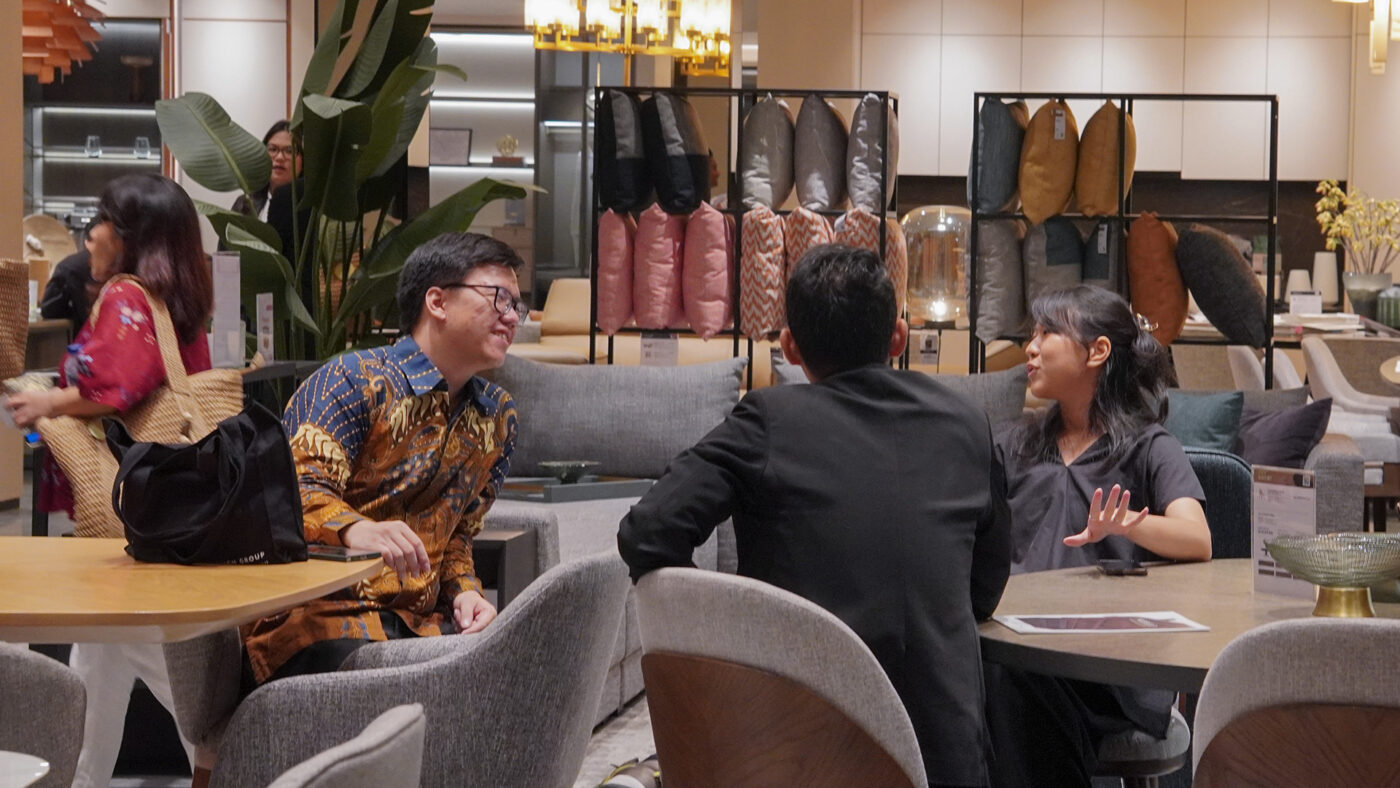 Guests in conversation inside the Modulo Living showroom surrounded by elegant furniture displays.
